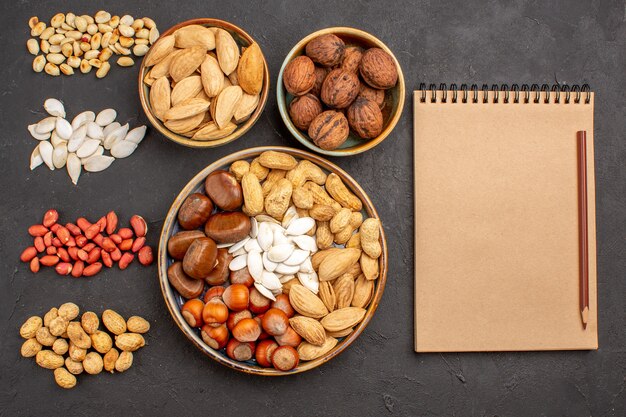 Top view of nut composition with different fresh nuts on dark surface