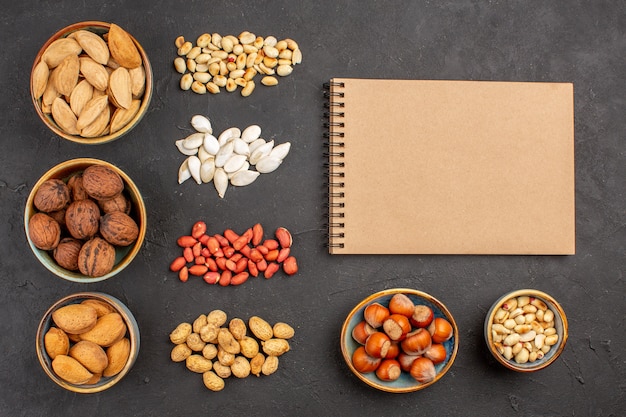 Top view of nut composition with different fresh nuts on dark surface