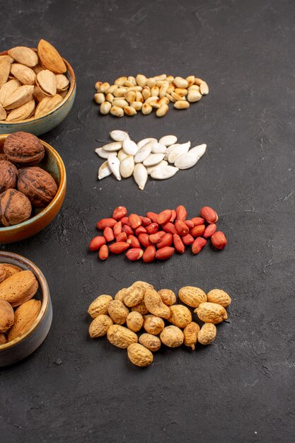 Top view of nut composition with different fresh nuts on dark surface