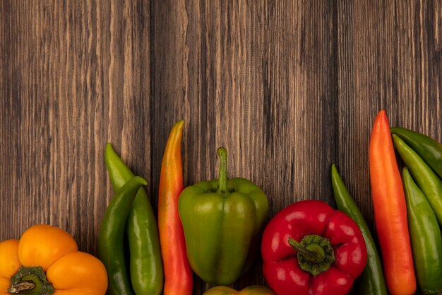 Top view of nutritional bell and chili peppers isolated on a wooden wall with copy space