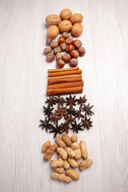 Top view nuts and cinnamon different kinds of nuts and cinnamon sticks on the white table