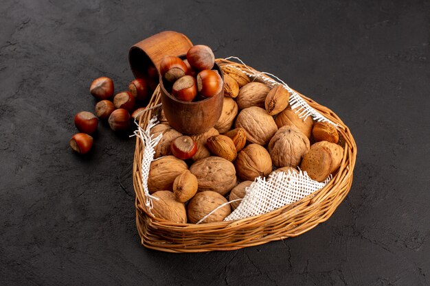 top view nuts hazelnuts and walnuts whole inside basket on the dark floor