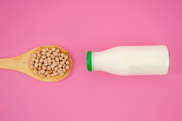 Top view nuts spoon with milk on pink background   