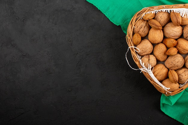 top view nuts whole inside basket on the green tissue and grey background