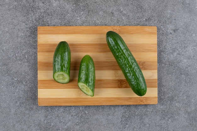 Free photo top view o fresh organic cucumbers on wooden board.