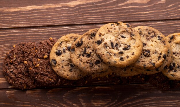 Top view of oatmeal cookies with chocolate chips nuts and cocoa on a wooden