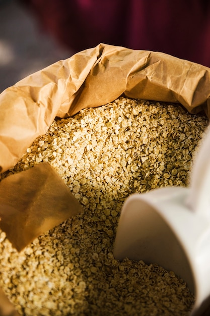 Foto gratuita vista dall'alto di avena con scoop in sacchetto di carta al supermercato