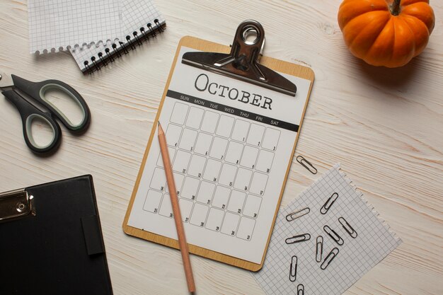 Top view october calendar and pumpkin