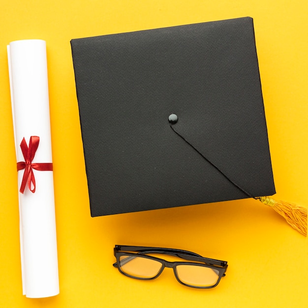 Бесплатное фото Вид сверху академической шапки с дипломом и очками