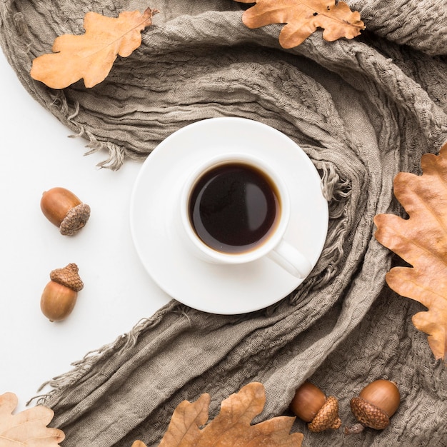 Бесплатное фото Вид сверху кофейной чашки с текстилем и осенними листьями