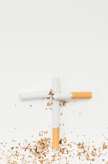 흰색 배경에 대해 부러진 담배로 만든 크로스 기호의 상위 뷰