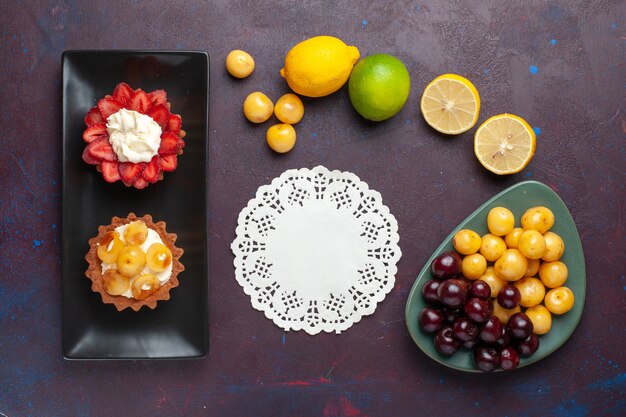 무료 사진 어두운 표면에 신선한 레몬과 과일 접시 안에 맛있는 크림 케이크의 상위 뷰