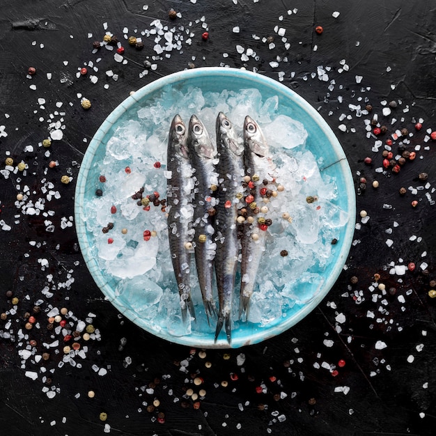 Бесплатное фото Вид сверху рыбы на тарелке со льдом и специями