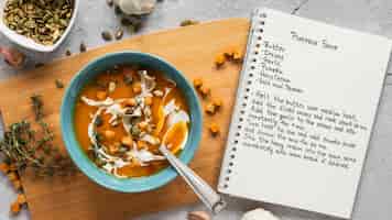 無料写真 野菜スープボウルとノートブックと食材の上面図