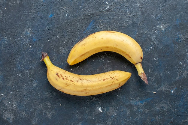 無料写真 紺色の机の上で甘くておいしい新鮮な黄色のバナナの上面図、フルーツベリーの甘いビタミンの健康