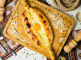 Бесплатное фото Вид сверху грузинского хачапури с сыром и яйцом