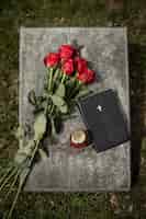 Бесплатное фото Вид сверху на надгробие с цветами и свечой