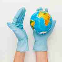 無料写真 地球を保持している手袋の手の平面図