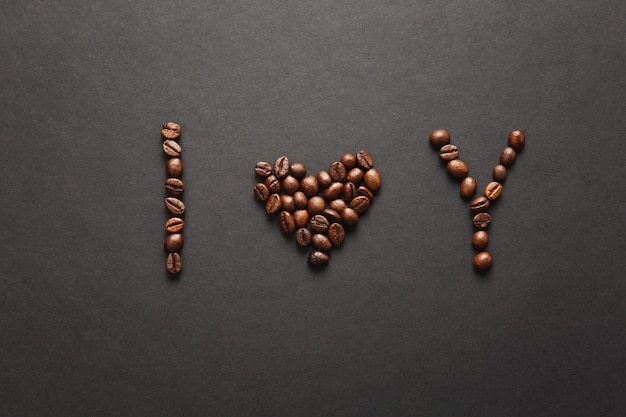 I Love You 편지의 상위 뷰 - 디자인을 위해 배경에 있는 커피 콩으로 만든 U 단어를 마음에 듭니다. 2월 14일, 휴일 개념에 성 발렌타인 데이 카드. 광고 공간을 복사합니다. 프리미엄 사진