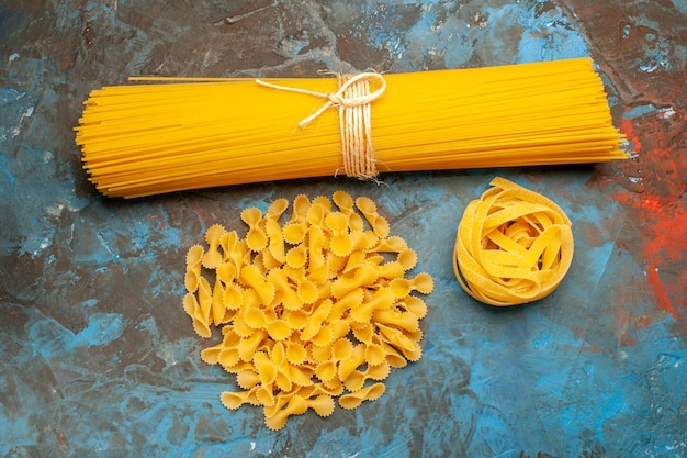 Бесплатное фото Вид сверху различных итальянских паст для приготовления обеда на синем фоне