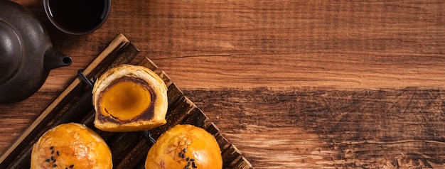 Вид сверху на лунное тесто с желтком, лунный пирог для праздника середины осени на фоне деревянного стола