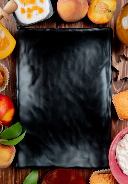 Бесплатное фото Вид сверху продолговатой тарелки с творожно-персиковым кексом на деревянной поверхности