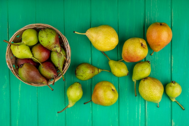 Бесплатное фото Вид сверху персиков в корзине на зеленой поверхности