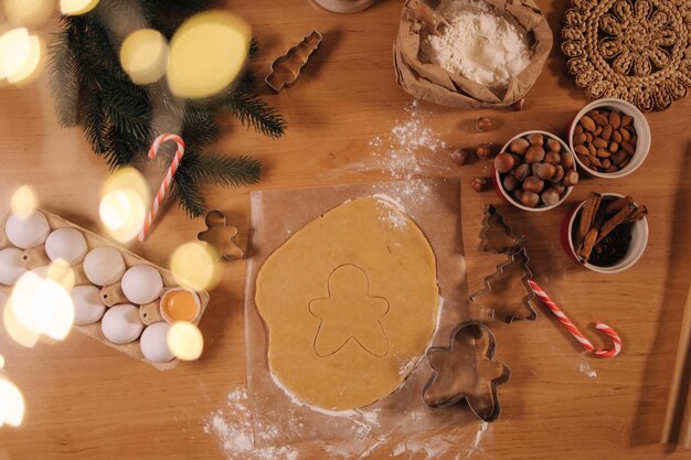 베이킹을 준비하는 나무 테이블에 크리스마스 쿠키 생강 남자를 요리하기 위한 원시 반죽의 상위 뷰