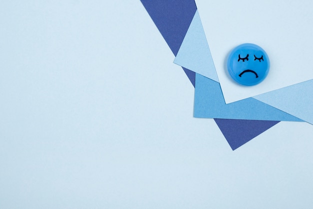 Бесплатное фото Вид сверху грустного лица на синий понедельник с бумагой