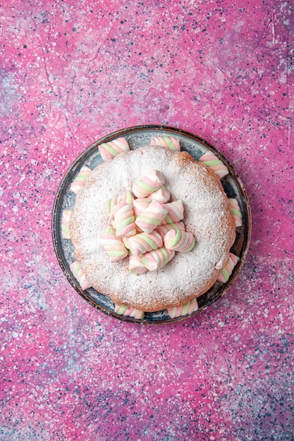 Бесплатное фото Вид сверху сахарной пудры с зефиром на розовой поверхности