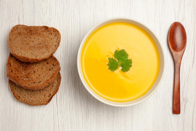Бесплатное фото Вид сверху вкусного тыквенного супового крема с текстурой темного хлеба на белом
