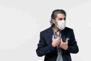 Бесплатное фото Вид сверху неуверенного эмоционального молодого бизнесмена в костюме с хирургической маской на белом фоне