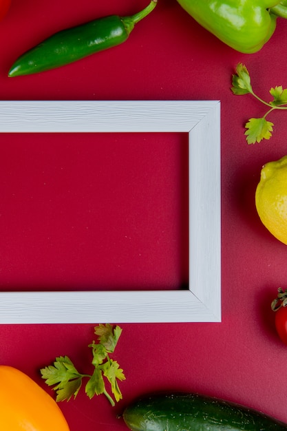 Бесплатное фото Взгляд сверху овощей как кориандр перца огурца с лимоном и рамка на поверхности bordo с космосом экземпляра
