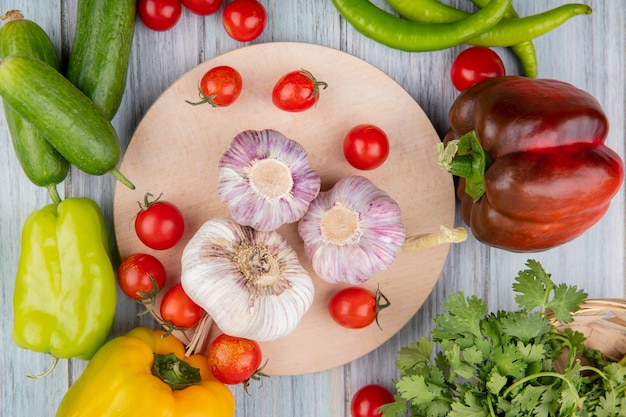 Бесплатное фото Взгляд сверху овощей как томат чеснока на разделочной доске с перцем укропа огурца на деревянной поверхности