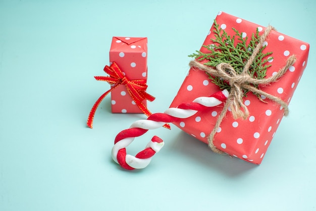 파스텔 녹색 배경에 빨간색 선물 상자와 사탕이 있는 크리스마스 배경의 상위 뷰