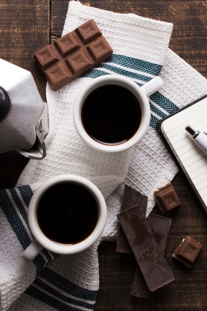 Top view office cups of coffee and chocolate