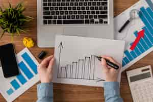 Free photo top view of office desk with calculator and growth chart