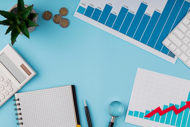 Top view of office desk with growth chart and coins