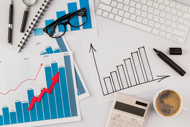 Top view of office desk with growth chart and glasses