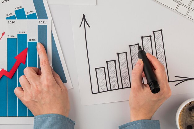 Free photo top view of office desk with growth chart and hands