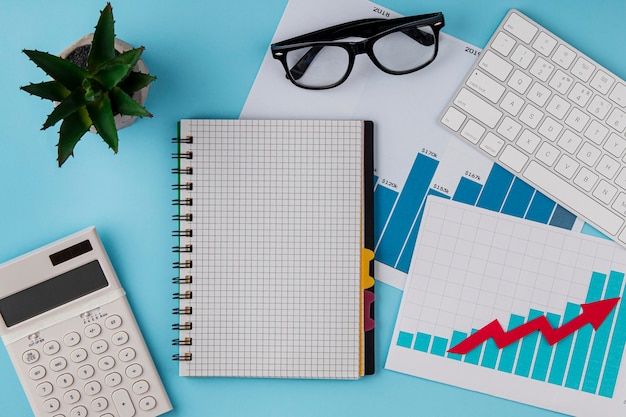 Free photo top view of office desk with growth chart and keyboard