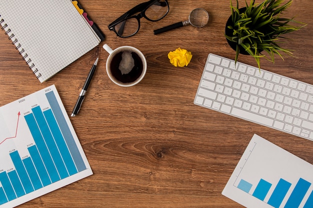 Free photo top view of office desk with growth chart and keyboard