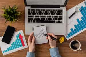 Free photo top view of office desk with laptop and growth chart