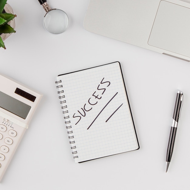 Top view of office desk with success on notebook