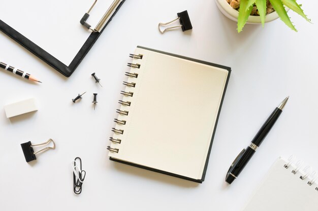 Top view of office stationery with notebook and pins