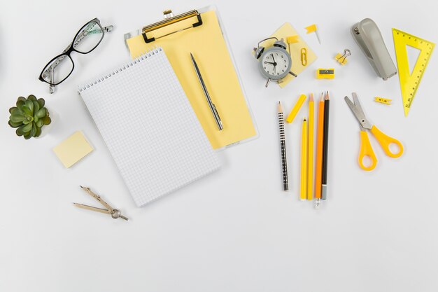 Top view office supplies with notepad on the table