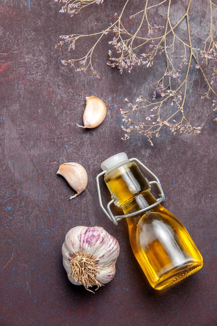 Free Photo top view of oil and garlic on black