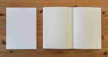 Free photo top view of open blank book next to pieces of paper