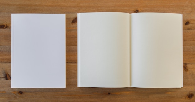 Top view of open blank book next to pieces of paper