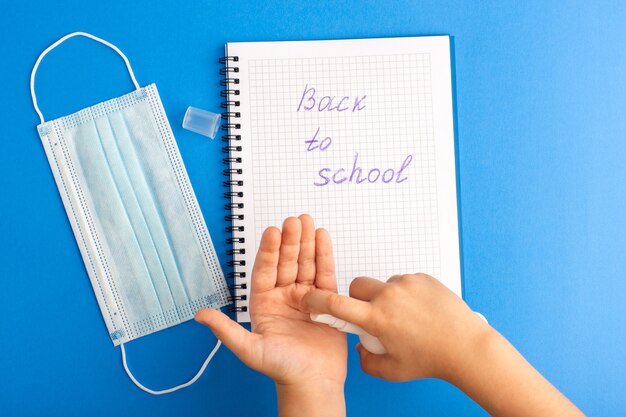 Top view open copybook child using spray on blue surface